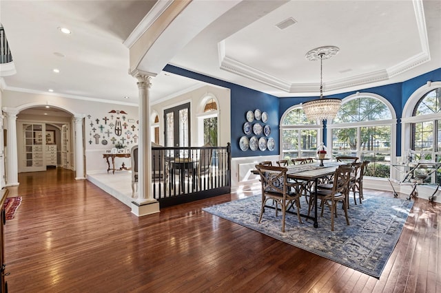 dining area with crown molding, a chandelier, ornate columns, and dark hardwood / wood-style flooring