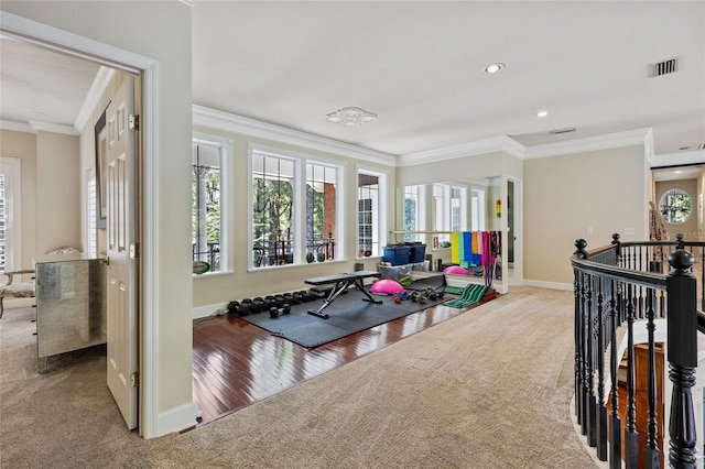 workout room with light hardwood / wood-style floors and crown molding