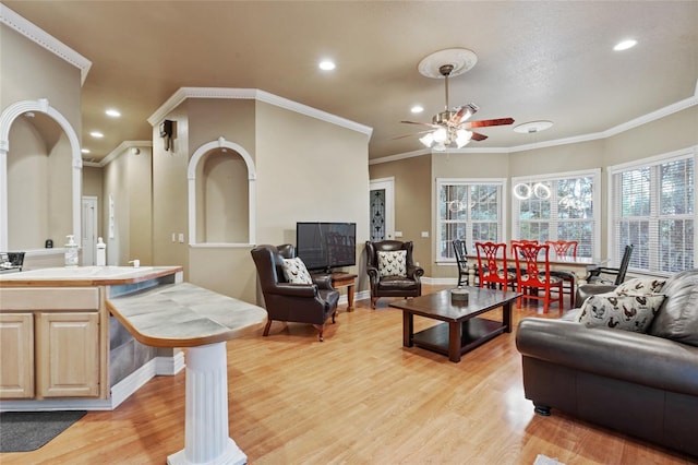 living room featuring crown molding, light hardwood / wood-style floors, and ceiling fan