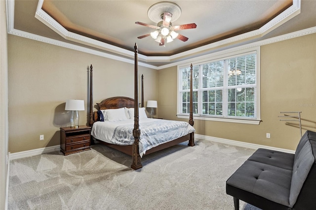 carpeted bedroom featuring crown molding, ceiling fan, and a raised ceiling