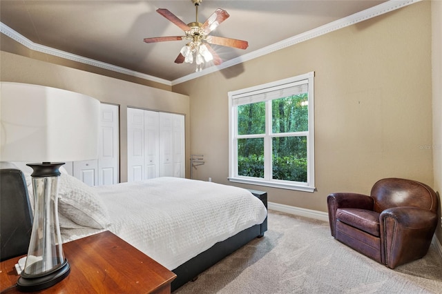 carpeted bedroom featuring crown molding, two closets, and ceiling fan