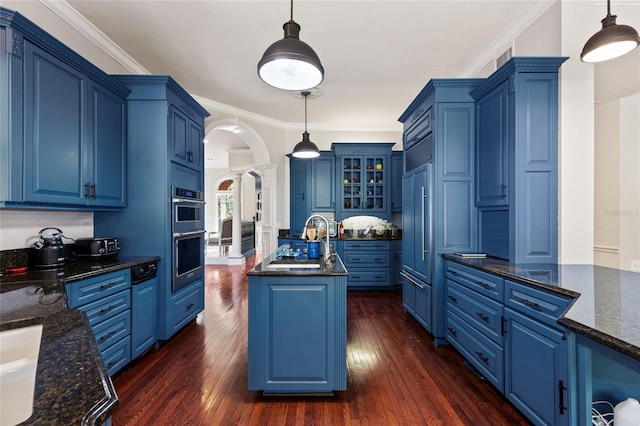 kitchen with blue cabinetry, hanging light fixtures, and dark hardwood / wood-style floors