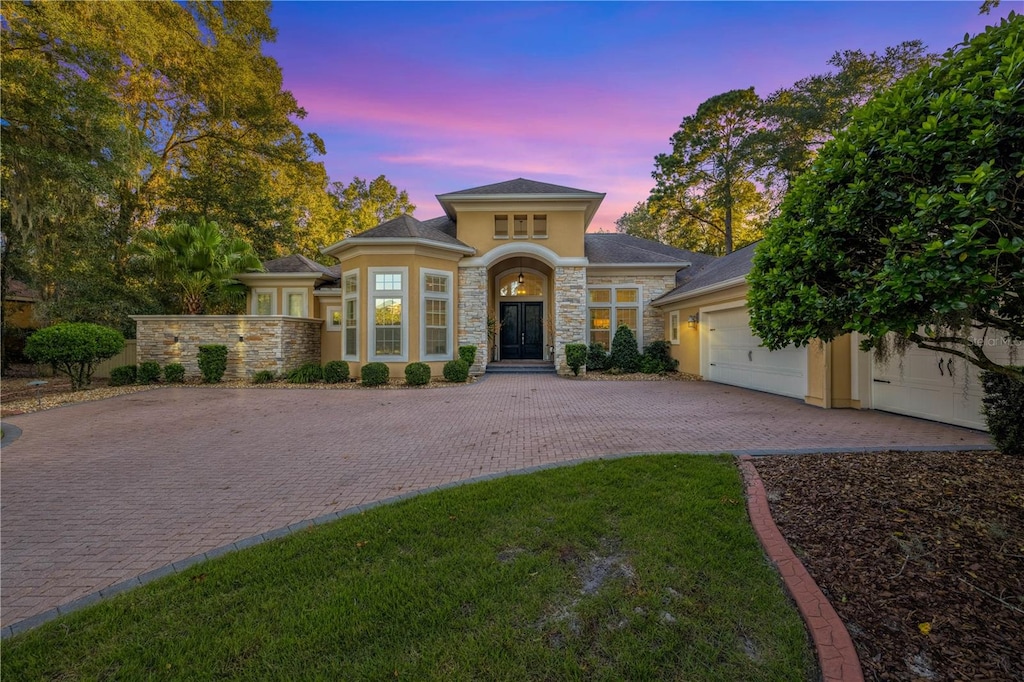 view of front of house featuring a garage and a lawn