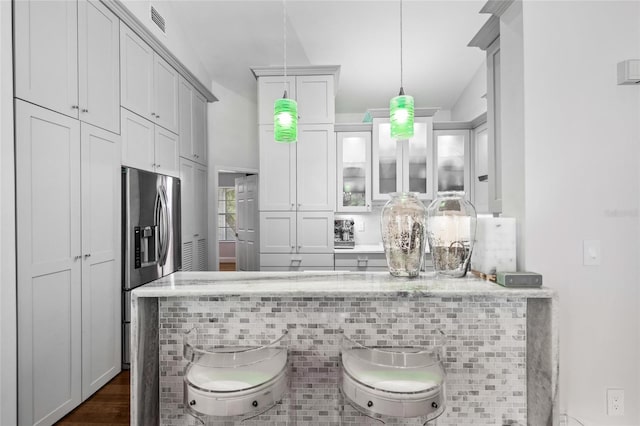 bar with backsplash, hanging light fixtures, white cabinetry, dark wood-type flooring, and stainless steel fridge with ice dispenser