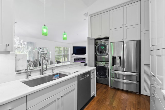 10000 SW 52nd Ave Unit 164, Gainesville, FL 32608 - kitchen with stainless steel appliances, stacked washer / dryer, light countertops, and dark wood finished floors