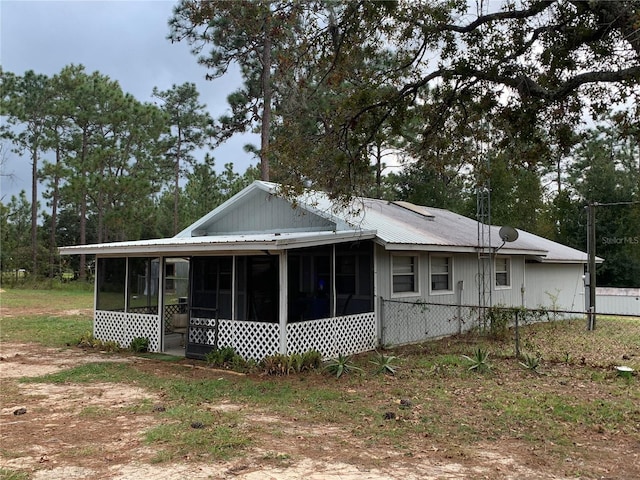 rear view of house featuring a sunroom