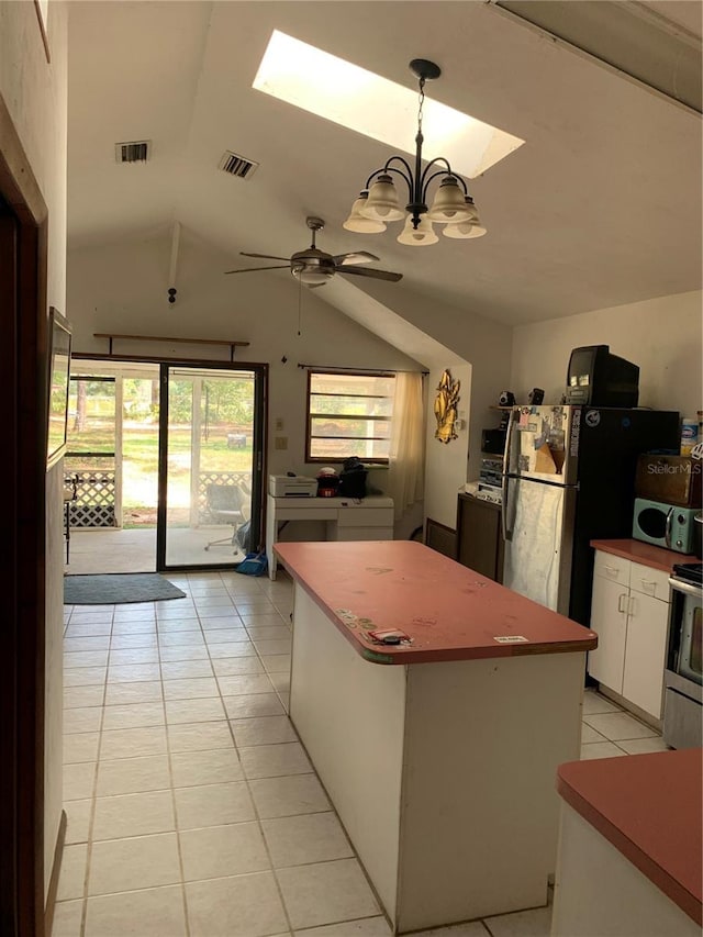 kitchen featuring a kitchen island, vaulted ceiling, decorative light fixtures, white cabinetry, and ceiling fan with notable chandelier