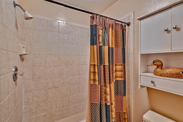 bathroom featuring toilet and curtained shower