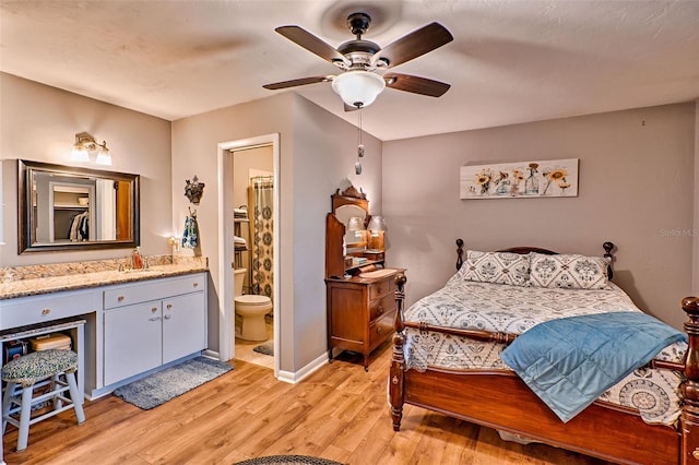 bedroom with sink, light hardwood / wood-style flooring, ensuite bathroom, and ceiling fan