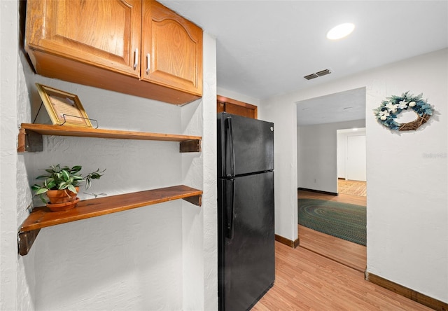 kitchen featuring light wood-type flooring and black refrigerator