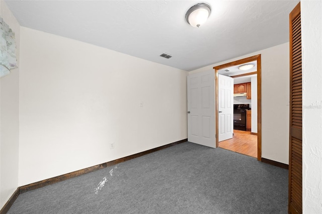 unfurnished bedroom featuring a closet and dark carpet