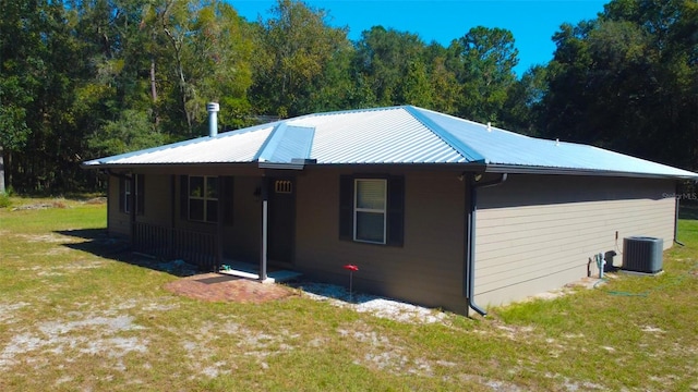 view of front of property featuring a front yard and cooling unit