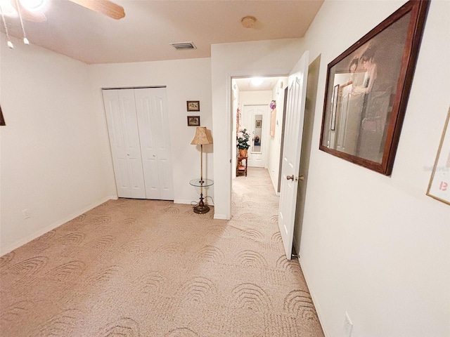 hall with light colored carpet