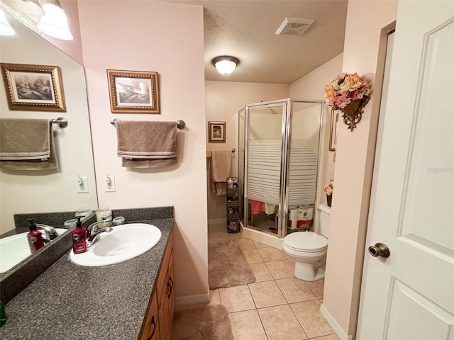 bathroom featuring vanity, a shower with shower door, toilet, and tile patterned floors