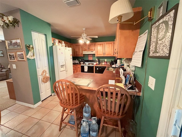 kitchen with kitchen peninsula, white refrigerator with ice dispenser, light tile patterned floors, electric stove, and ceiling fan