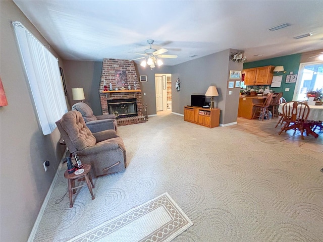 carpeted living room with a fireplace and ceiling fan