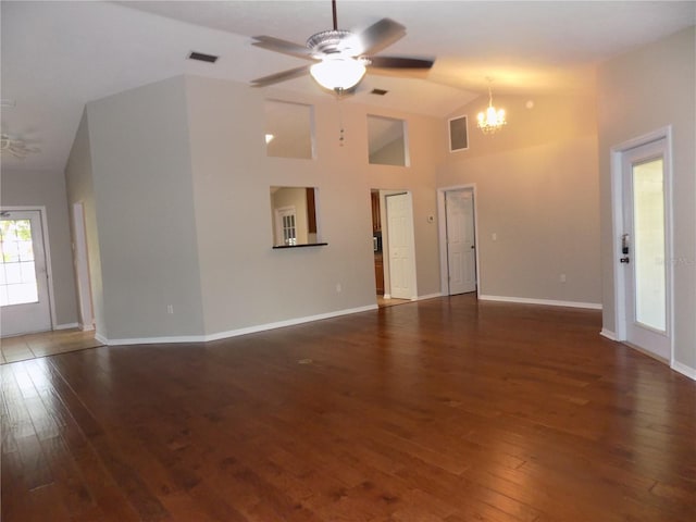 unfurnished living room with lofted ceiling, dark hardwood / wood-style floors, and ceiling fan with notable chandelier