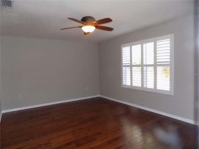 spare room featuring ceiling fan and dark hardwood / wood-style floors