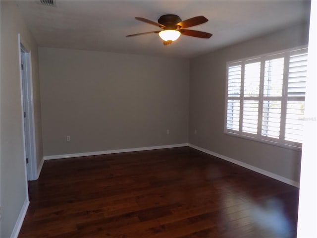 spare room featuring dark wood-type flooring and ceiling fan