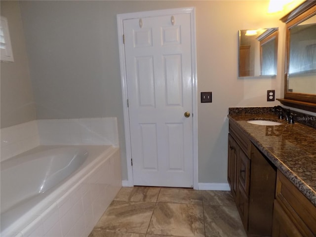 bathroom featuring vanity and tiled tub