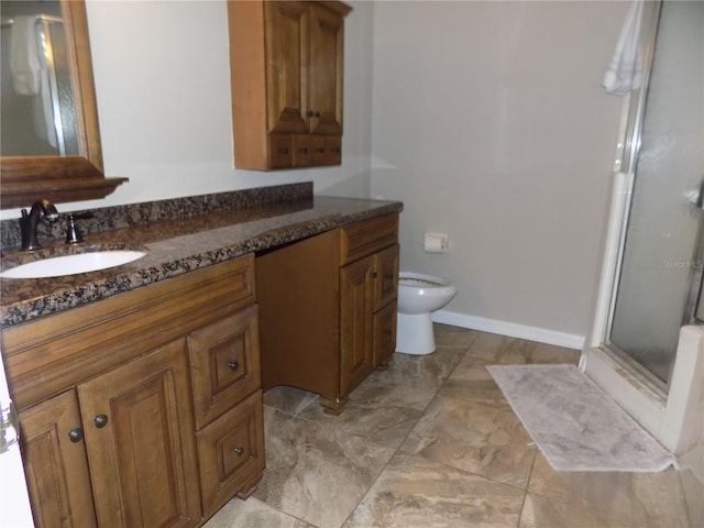 bathroom with vanity, a shower with shower door, and toilet