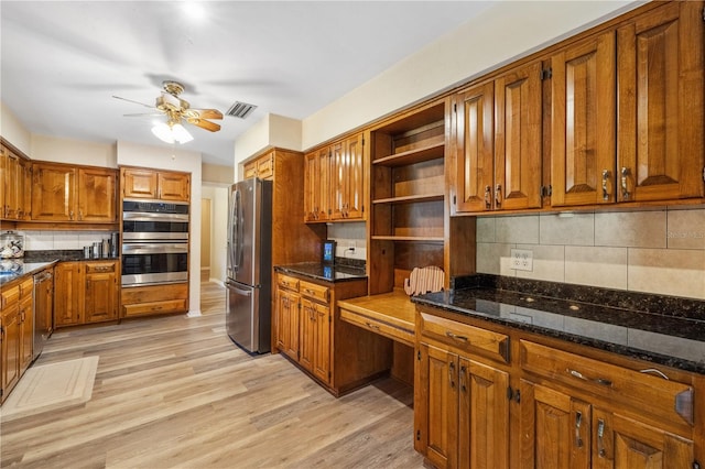 kitchen featuring built in desk, decorative backsplash, light hardwood / wood-style flooring, and stainless steel appliances