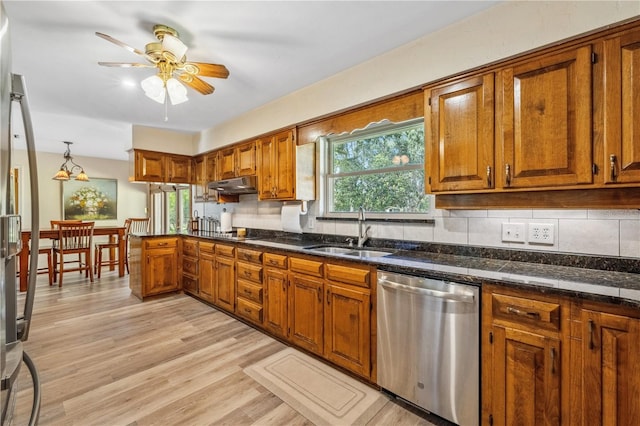 kitchen featuring sink, decorative backsplash, dishwasher, and light wood-type flooring