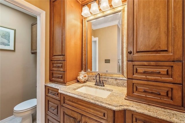 bathroom featuring vanity, crown molding, and toilet