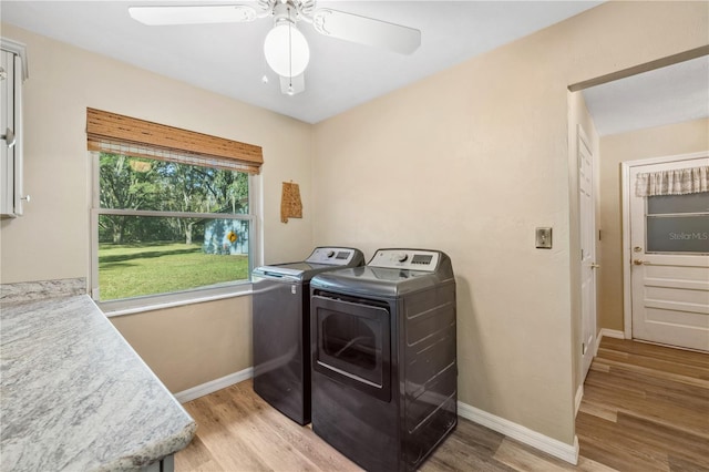 clothes washing area with light hardwood / wood-style flooring, separate washer and dryer, and ceiling fan