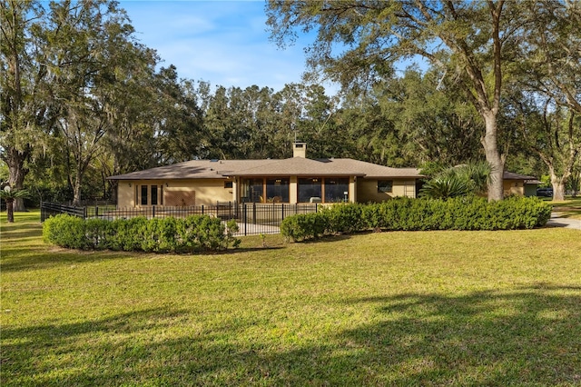 rear view of property featuring a lawn