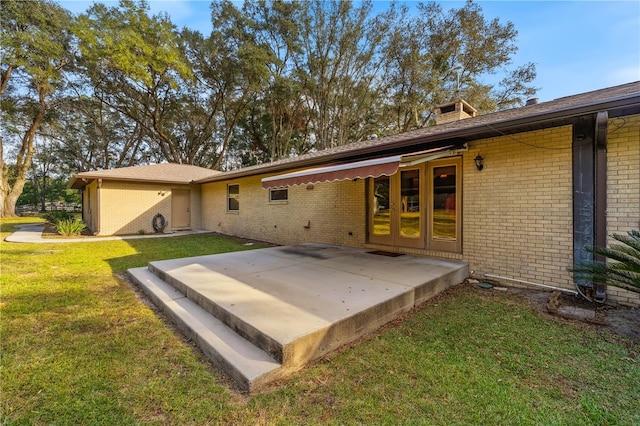 back of property with a patio area and a lawn