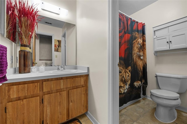 bathroom featuring toilet, vanity, a shower with shower curtain, and tile patterned flooring