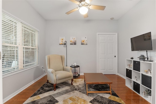 living area featuring wood-type flooring and ceiling fan