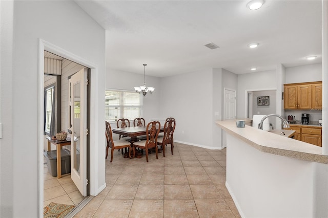 kitchen with hanging light fixtures, a notable chandelier, and light tile patterned floors