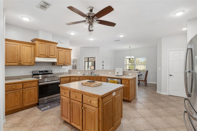 kitchen featuring ceiling fan with notable chandelier, a center island, hanging light fixtures, sink, and appliances with stainless steel finishes