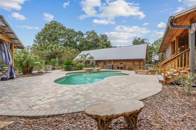 view of swimming pool featuring a patio area and an in ground hot tub