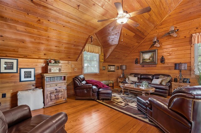 living room featuring lofted ceiling, wood ceiling, light hardwood / wood-style flooring, ceiling fan, and wood walls