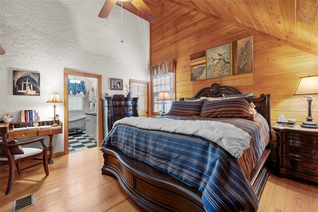 bedroom featuring wooden walls, wooden ceiling, and light wood-type flooring