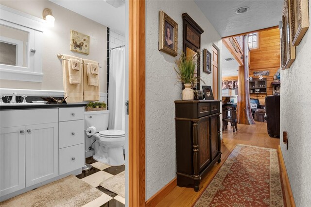 bathroom with vanity, wood-type flooring, curtained shower, and toilet