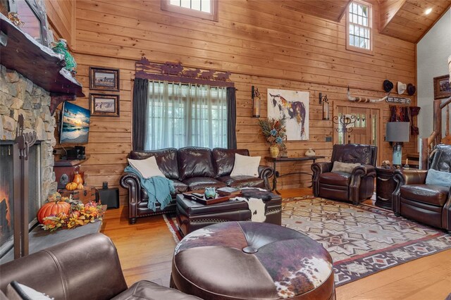 living room with wooden walls, light hardwood / wood-style floors, and a healthy amount of sunlight