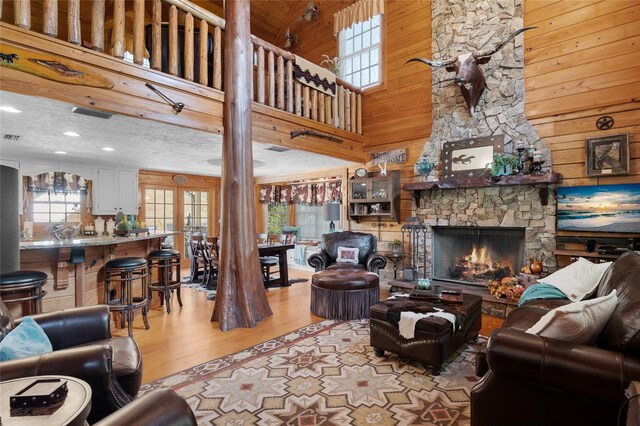 living room featuring a fireplace, light hardwood / wood-style flooring, and wood walls