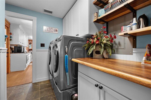 washroom featuring cabinets, separate washer and dryer, and dark tile patterned floors