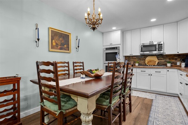 dining room with dark wood-type flooring and a notable chandelier