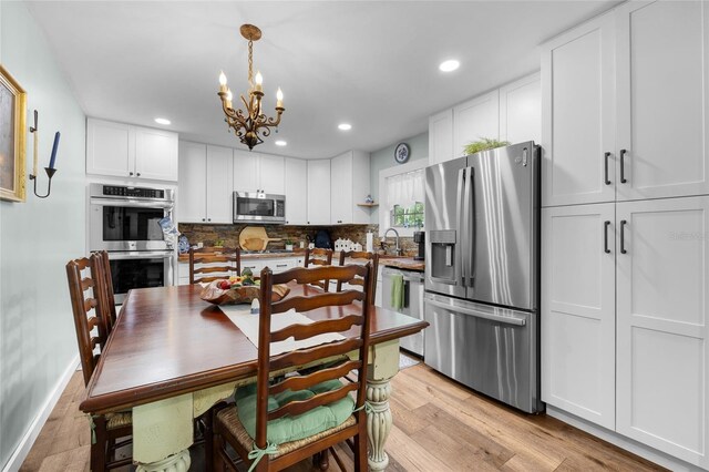 kitchen with white cabinetry, stainless steel appliances, decorative backsplash, and pendant lighting