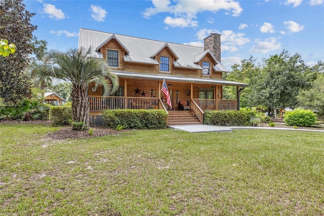 view of front of house with a front yard, ceiling fan, and covered porch