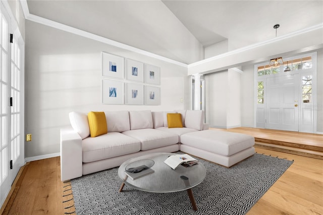 living room with crown molding, decorative columns, baseboards, and wood finished floors