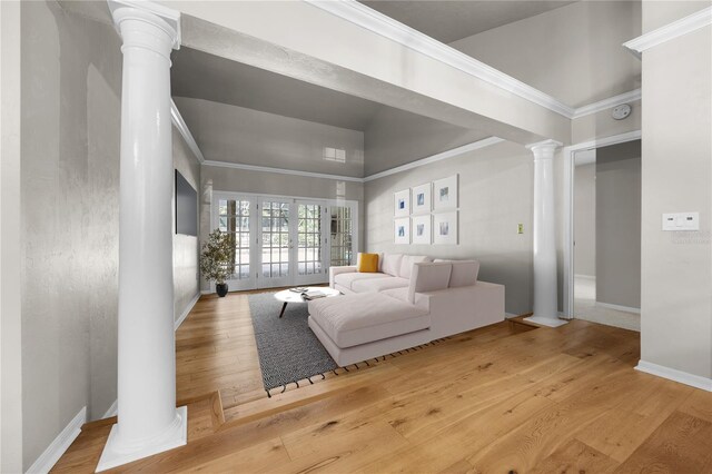 living room featuring decorative columns, ornamental molding, wood-type flooring, and baseboards