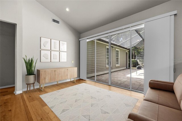 interior space with a sunroom, access to outside, visible vents, and wood finished floors