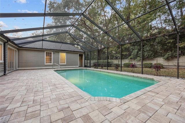 view of pool featuring glass enclosure, fence, a fenced in pool, and a patio