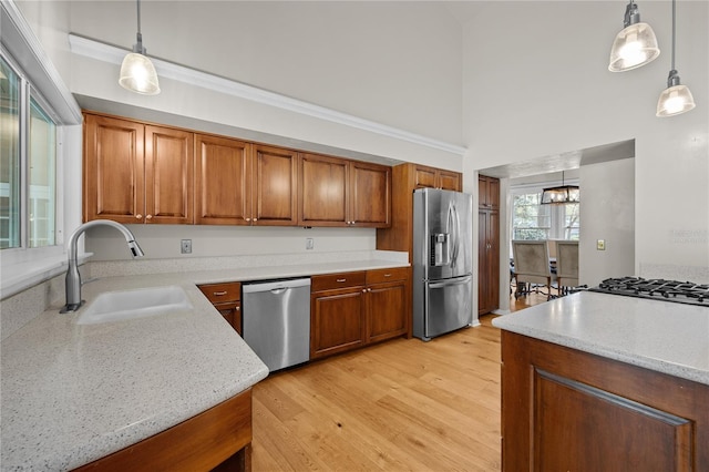 kitchen featuring brown cabinetry, stainless steel appliances, and a sink